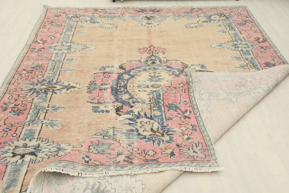 The vintage rug partially folded to show the wool pile and cotton foundation