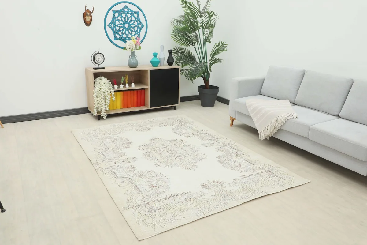 Ivory and gray vintage Anatolian rug placed in a modern living room setting with a light gray sofa