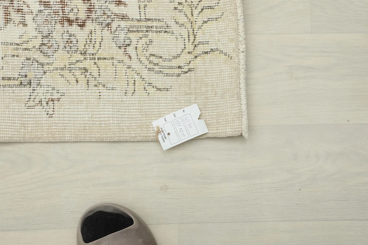 View of the back of the rug, showing the tight knotting and tag for authenticity