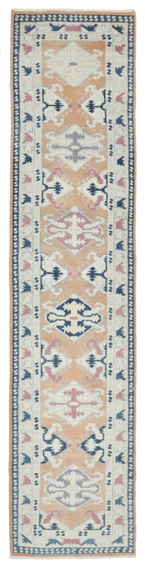 Full overhead view of the orange geometric Anatolian runner rug on a white background
