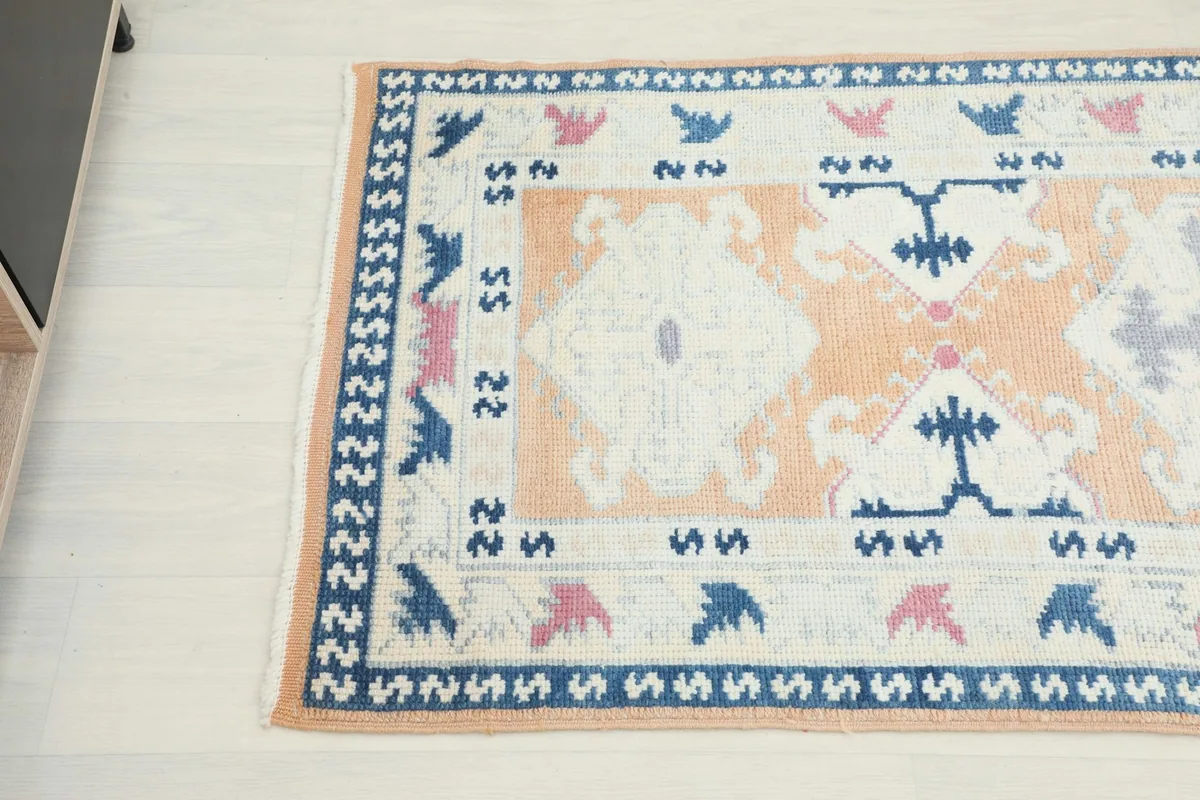 Overhead angled shot of the rug's pattern, showing the intricate geometric motifs and border design