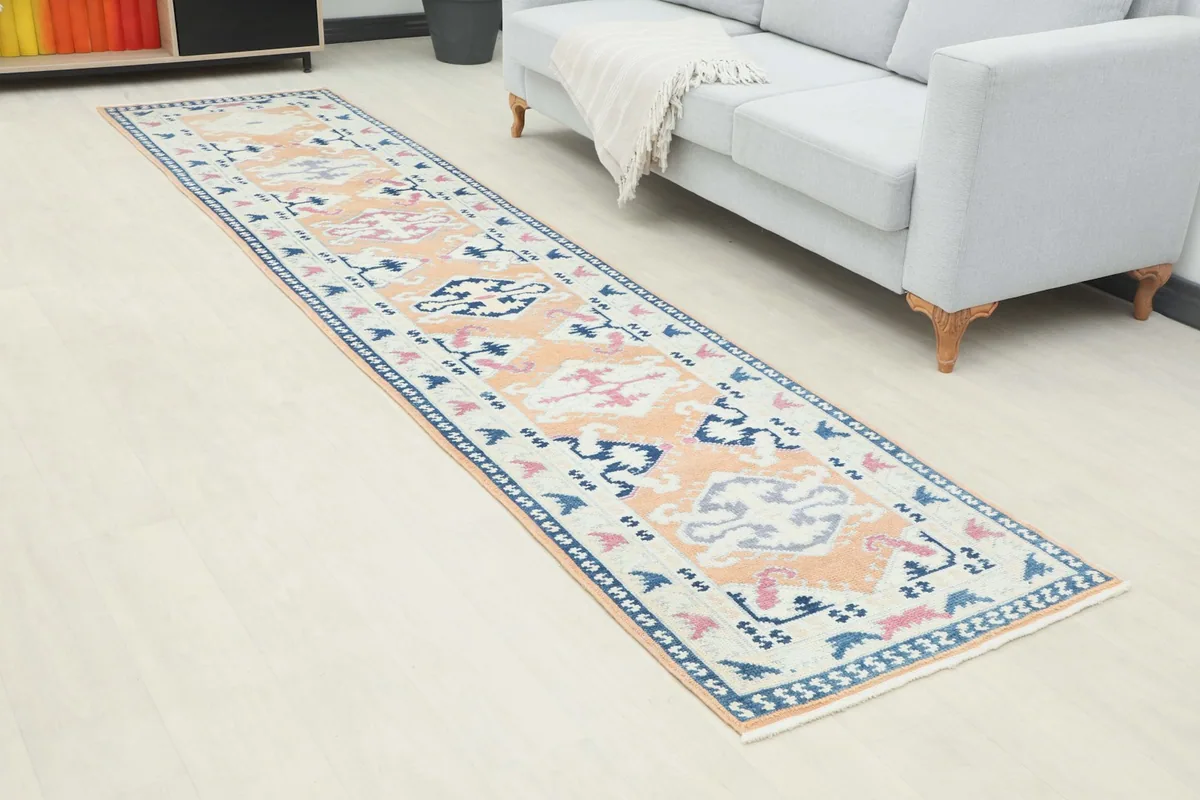 Angled view of the orange and navy runner rug in a room setting, showing its length