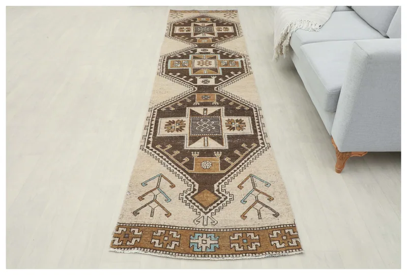 Full top view of the 2'8" x 10'11" beige and brown tribal runner rug on a white background.