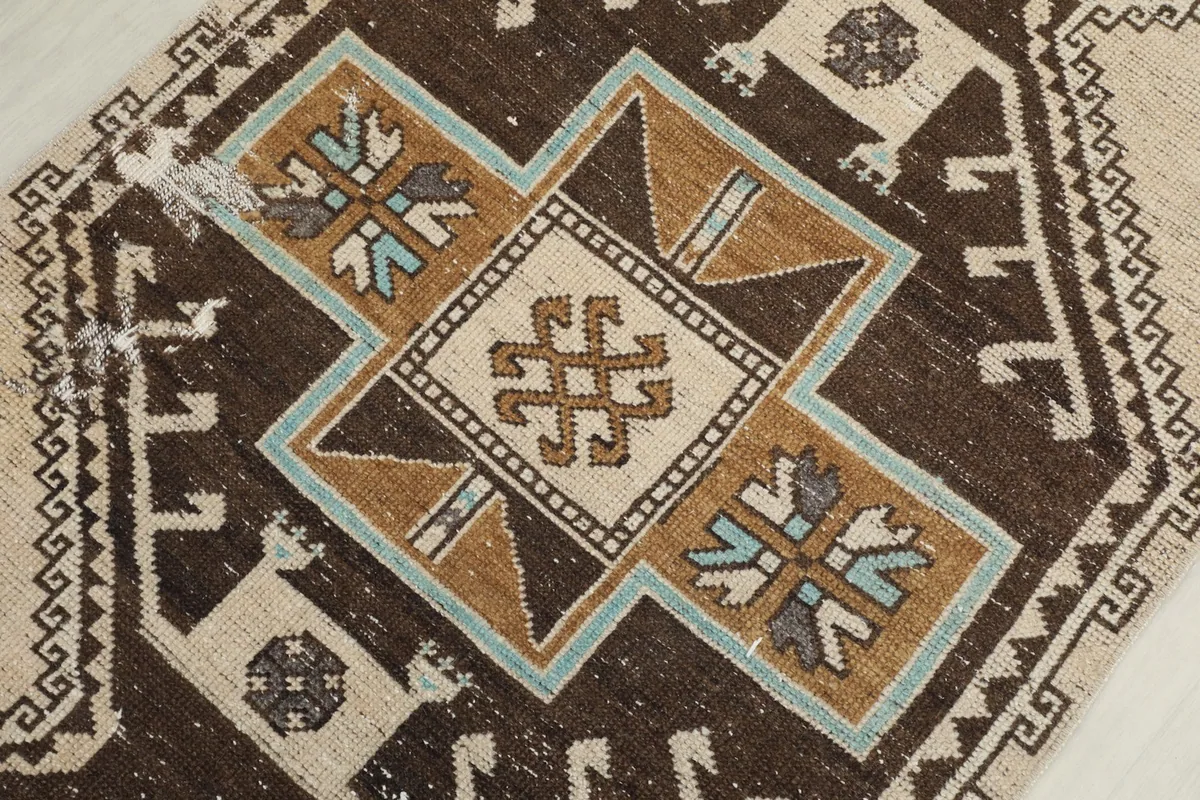 Detailed view of the central geometric medallion, showing brown, beige, blue, and tan colors.