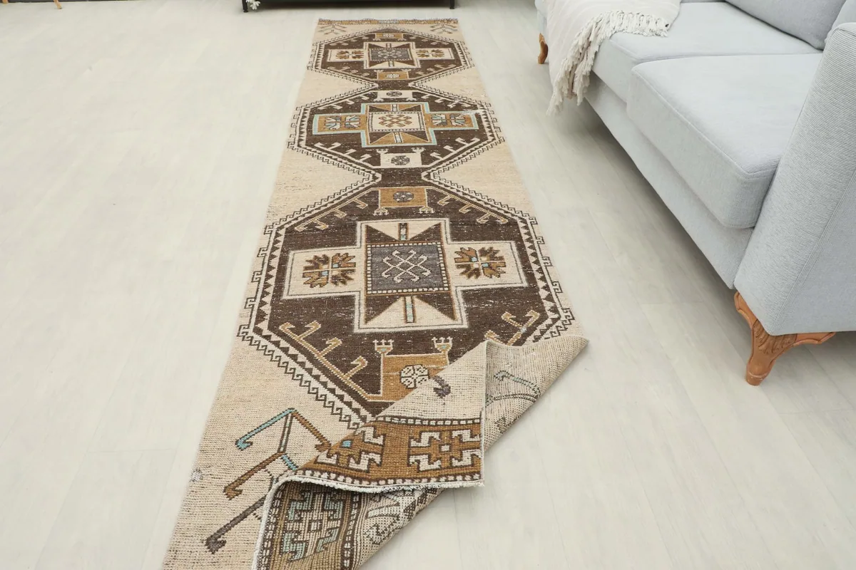 Runner rug partially folded, showing the thickness of the wool pile and the hand-knotted construction.
