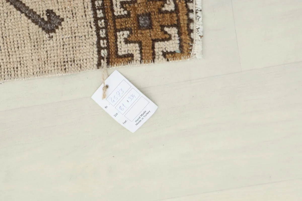 Rug's product tag displaying size and origin, placed on a light floor next to the runner.