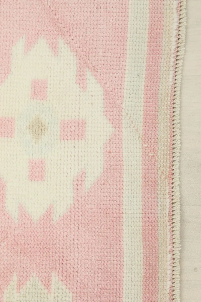 Close-up of the rug's edge, showing the hand-knotted construction and fringe details