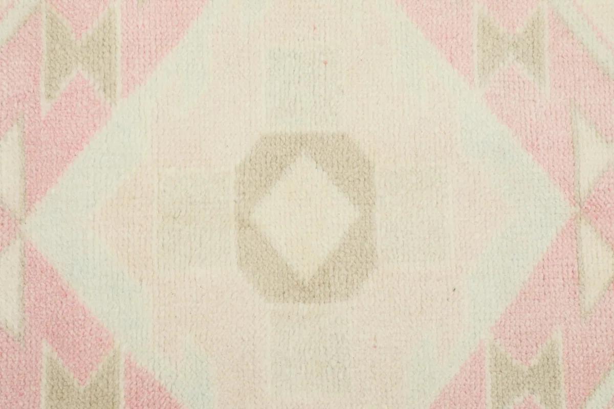 Detailed view of the low wool pile and the intricate knotting of the central motif