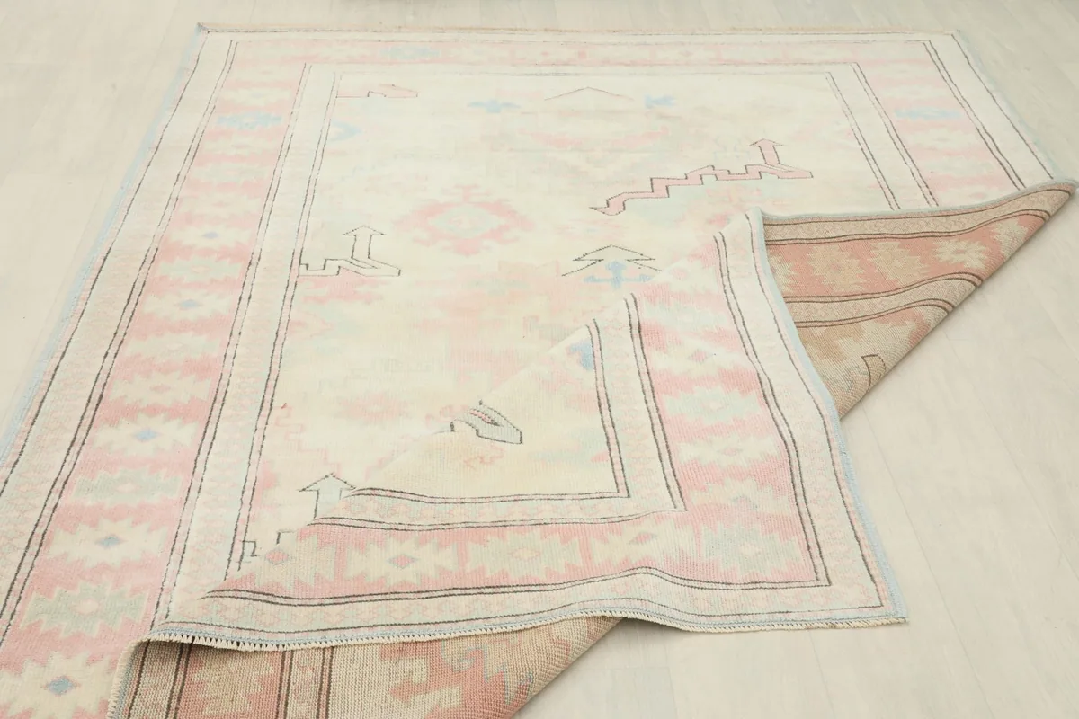 Partial view of the rug's backside, illustrating the hand-knotted wool pile on a cotton foundation.