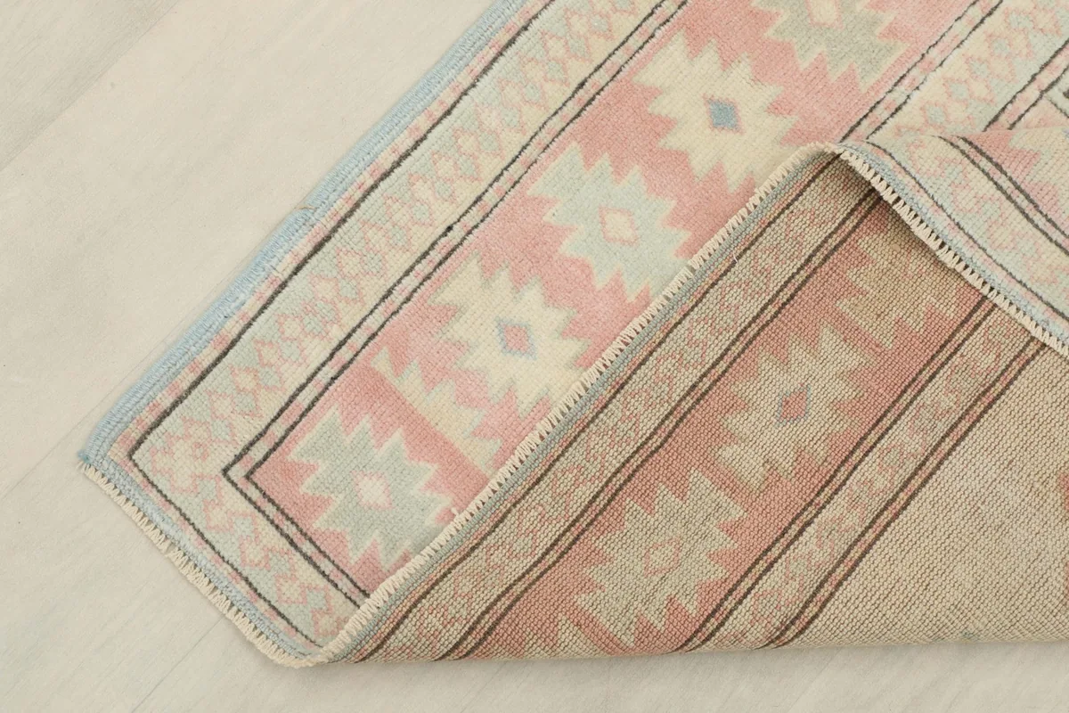 Corner of the rug folded to reveal the cotton foundation and the reverse side, showing craftsmanship.