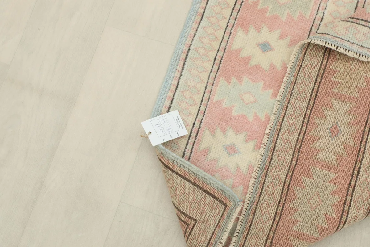 Close-up of the rug's corner with the product tag, showing the quality and origin details.