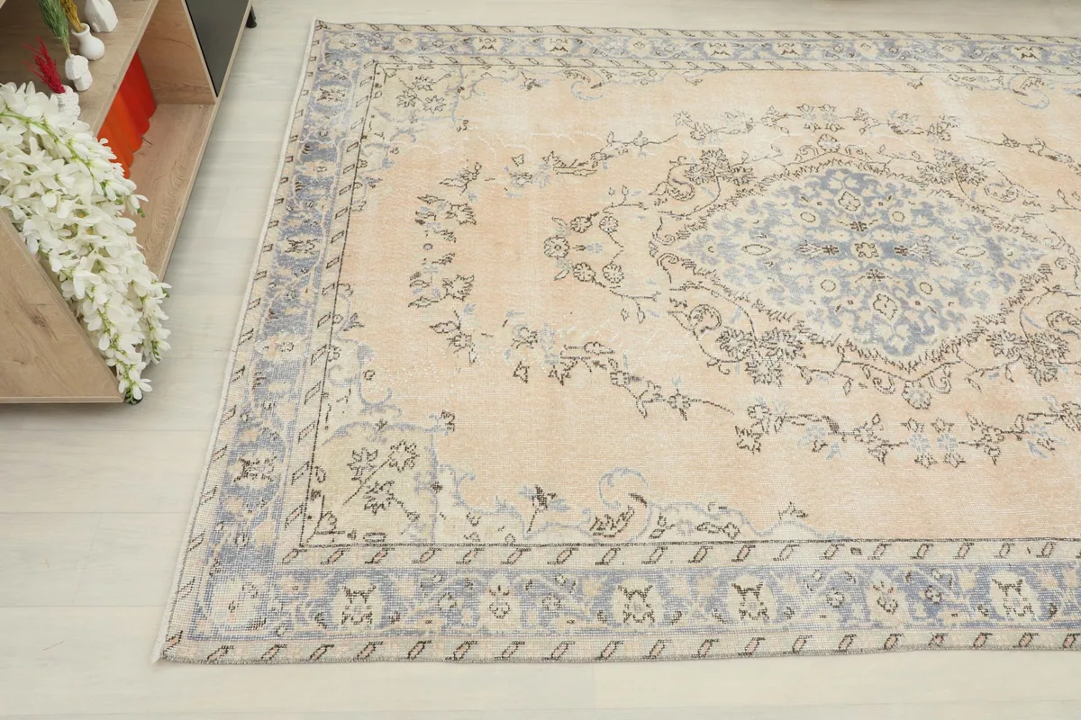 Detailed angle view of the rug's surface, capturing the central medallion and surrounding floral patterns.