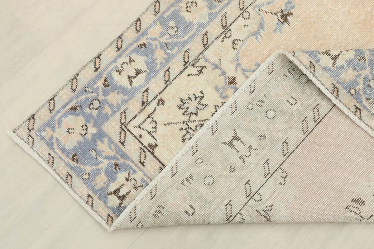 View of the rug's underside and corner folded back, showing the cotton foundation.
