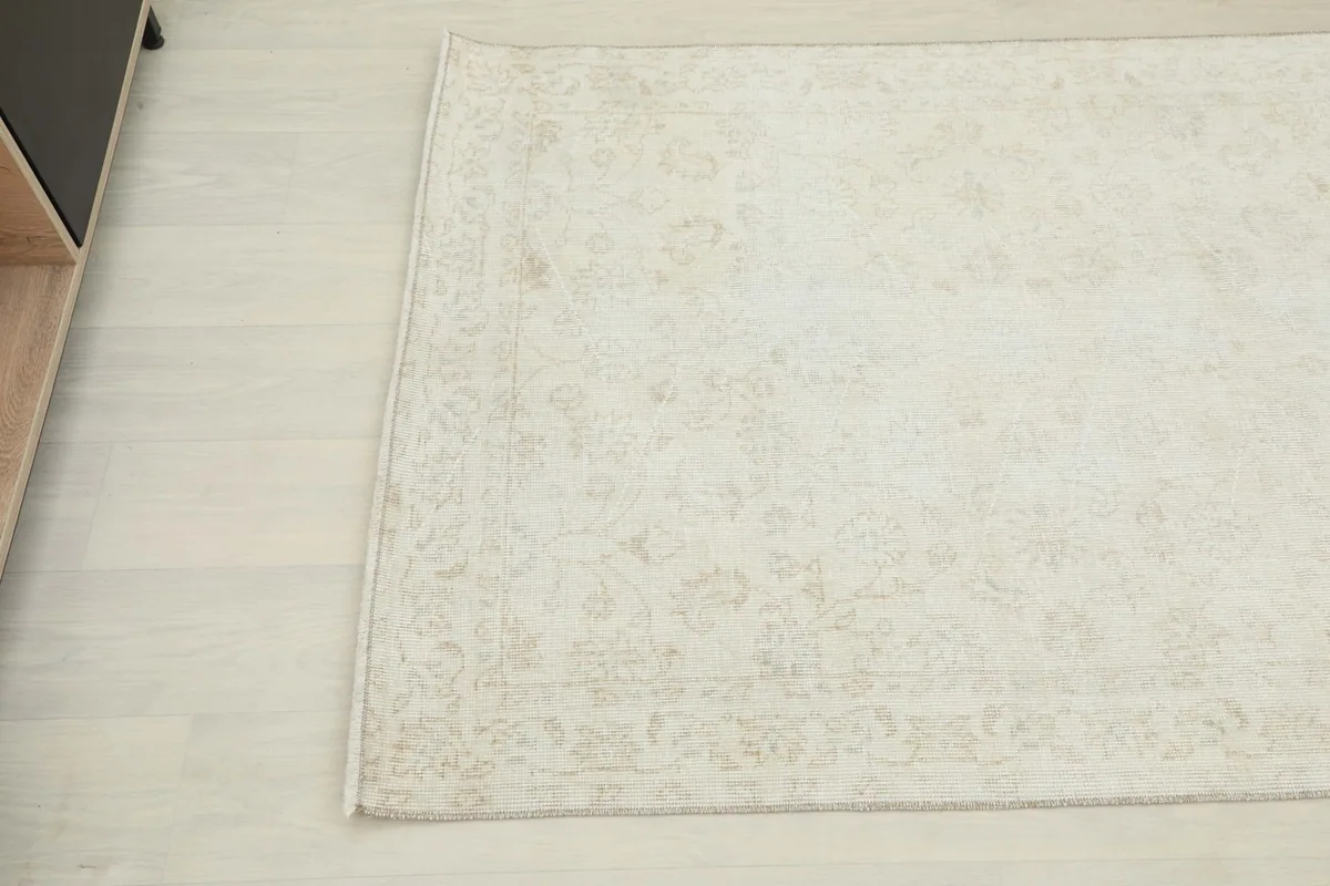 Close-up of the lower left corner of the rug, highlighting the vintage texture and colors