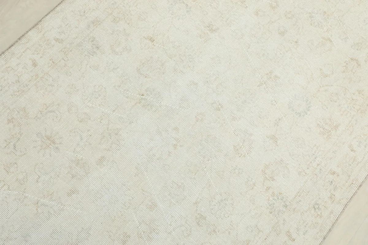 Detailed view of the rug's field, revealing faded botanical and geometric motifs