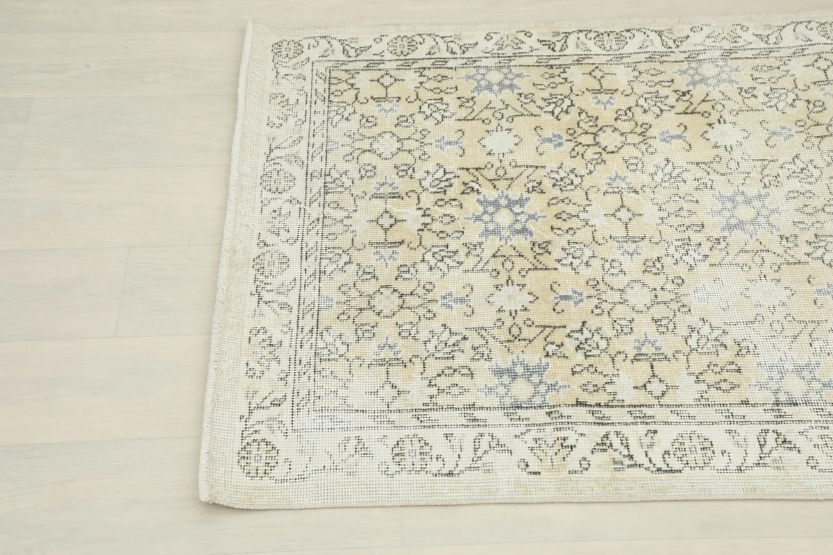 Angled view highlighting the faded beige field and gray floral patterns