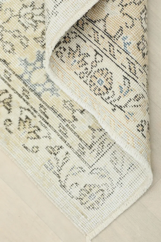 Corner of the rug folded back to reveal the back and construction
