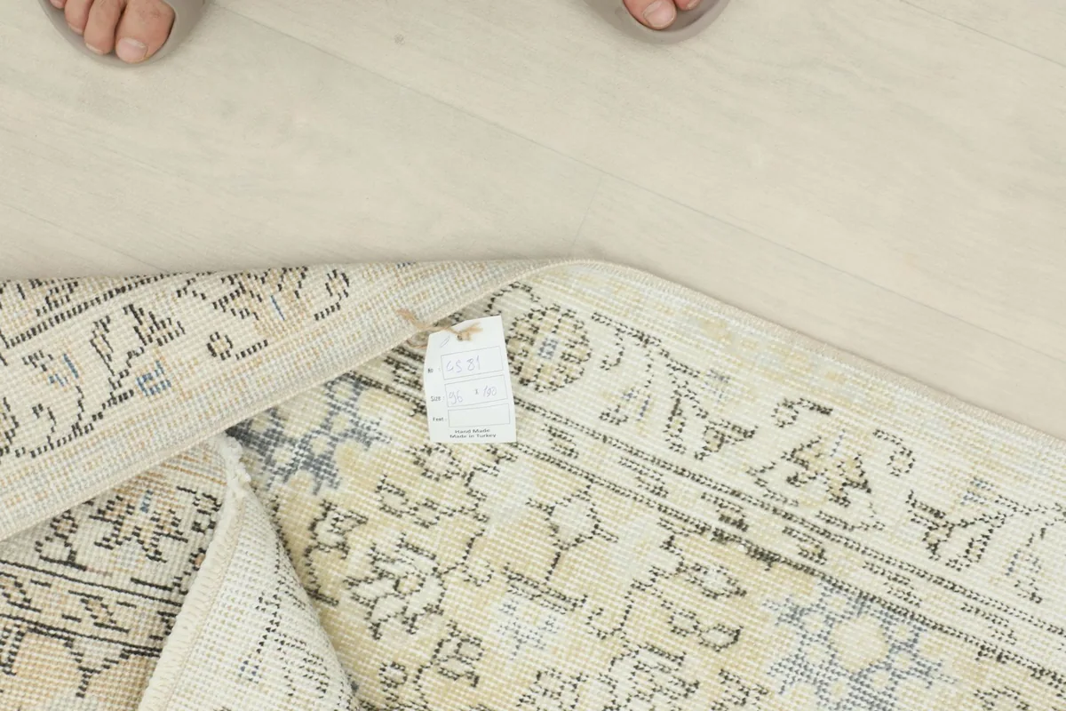 Close-up of the rug's label and a folded corner, showing the wool material