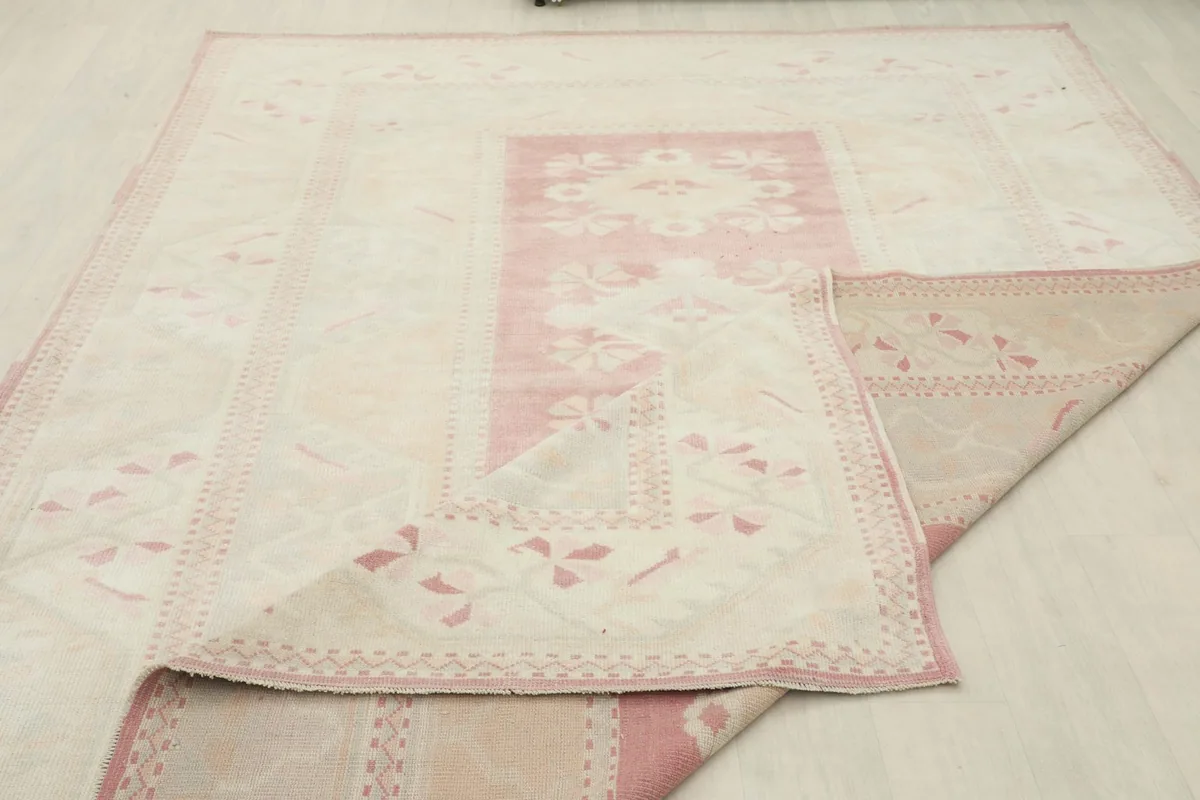Partial view of the rug's underside, showing the cotton foundation and hand-knotted structure