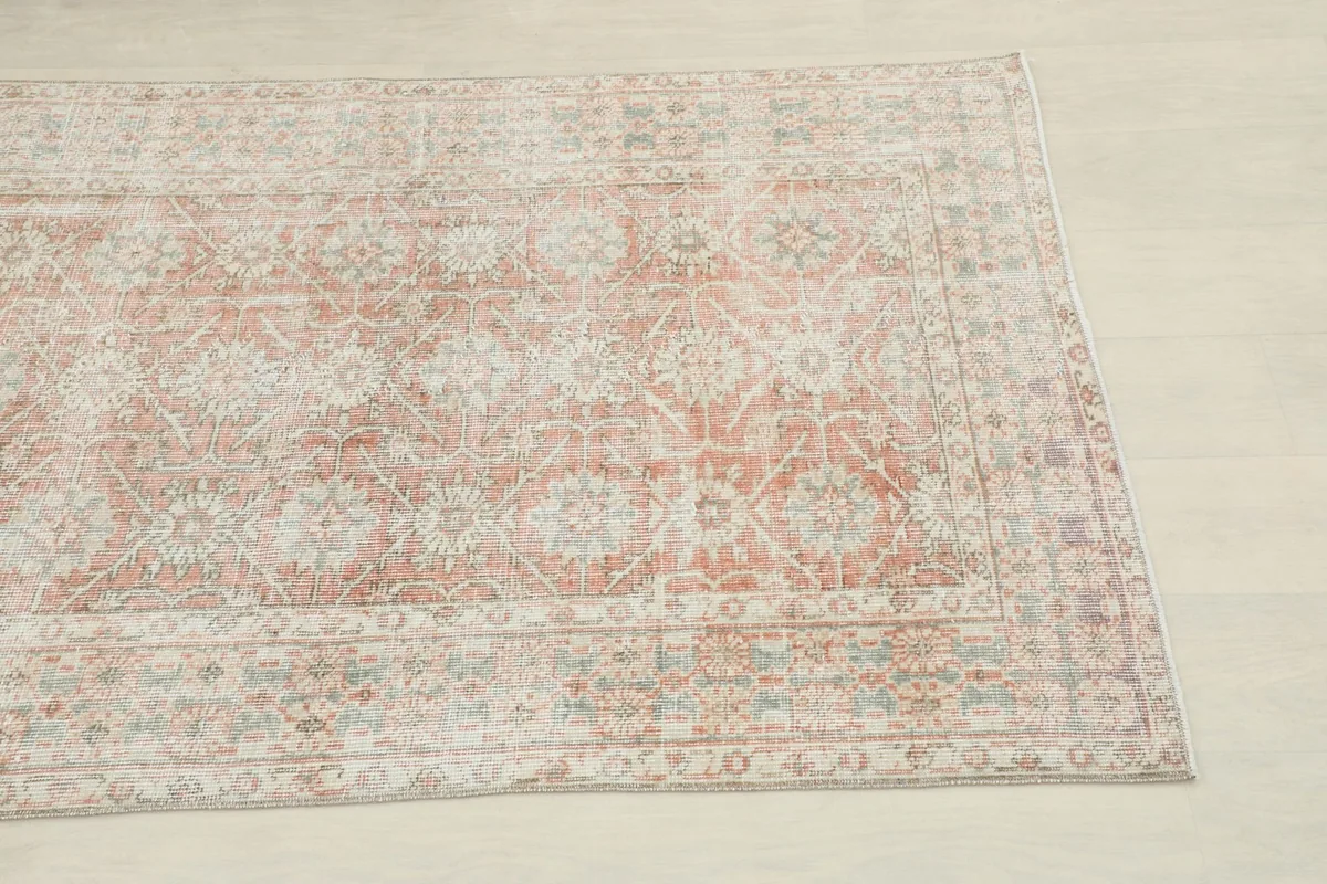 Close-up detail of the runner's central pattern, highlighting faded rose, beige, and blue floral motifs.