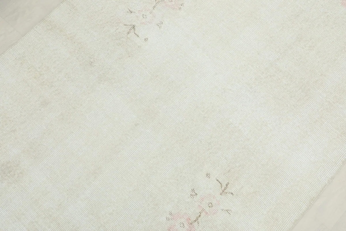 Mid-section detail highlighting the delicate floral design and gentle patina of the rug