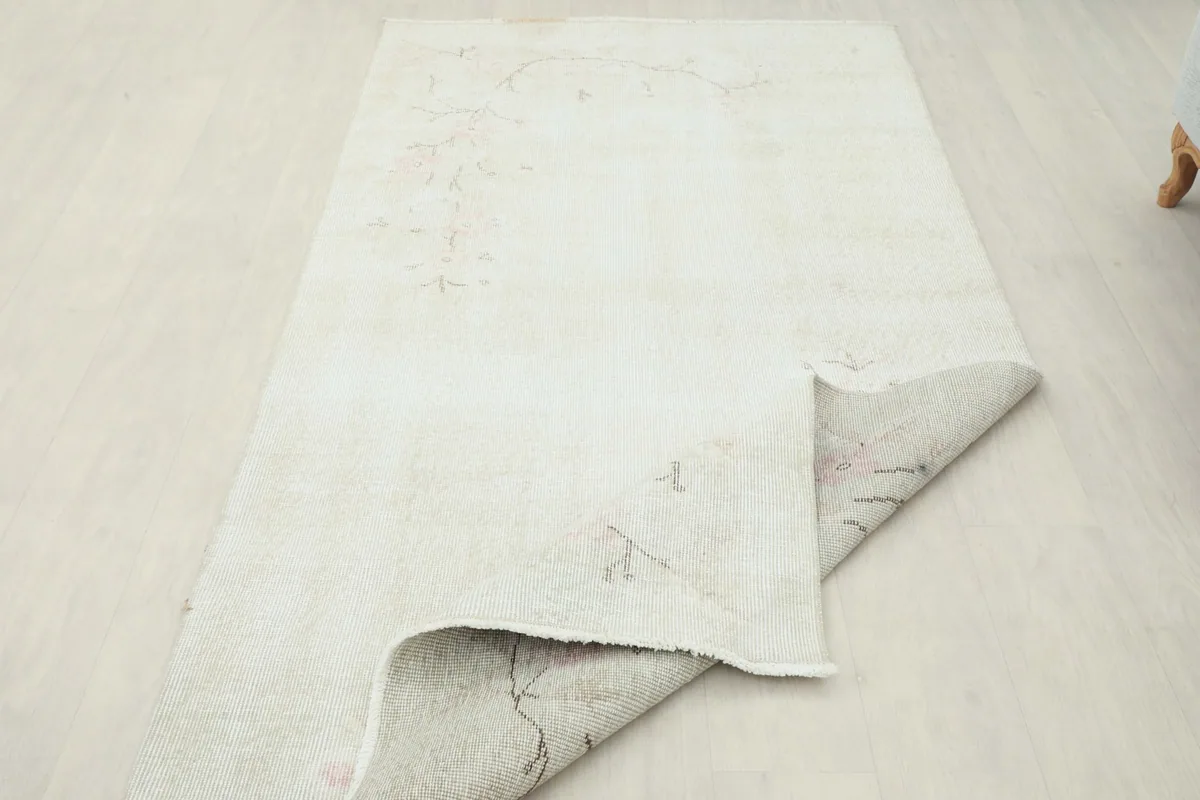 Rug partially folded, displaying the wool pile on the front and cotton foundation on the back