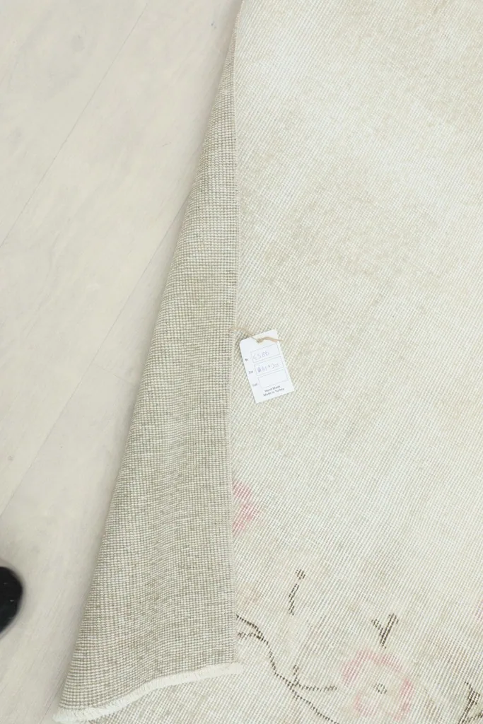 Side view of the rug with a tag, showing the thickness and construction