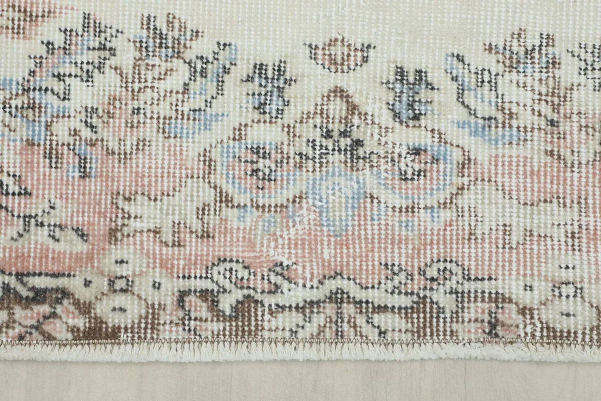 Side view of the rug's low wool pile and fringe, showing texture and colors