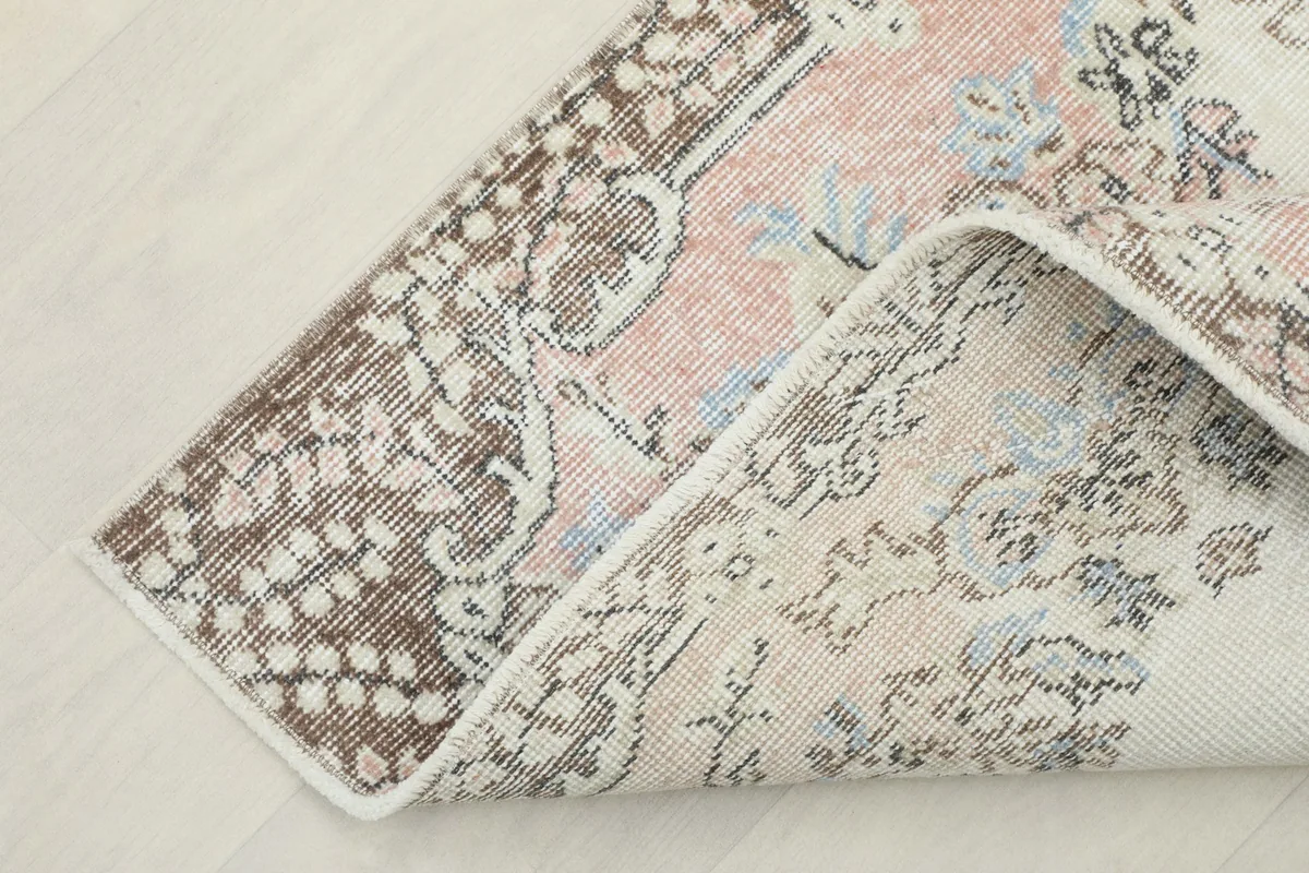 Corner of the rug folded to show the back of the hand-knotted cotton foundation