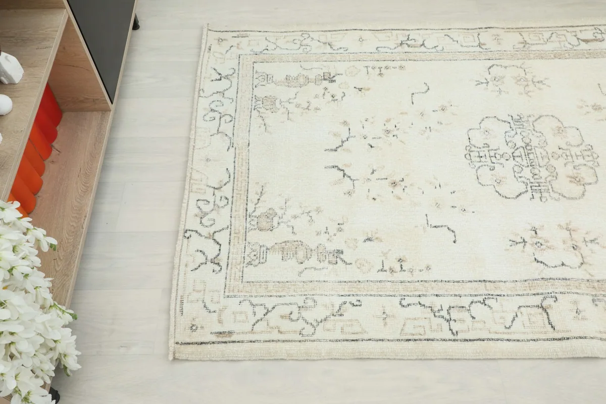 Overhead angle view capturing the floral and geometric details along one side of the rug.