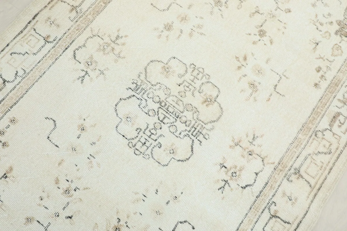 Detailed view of the central medallion design and surrounding floral elements on the rug.