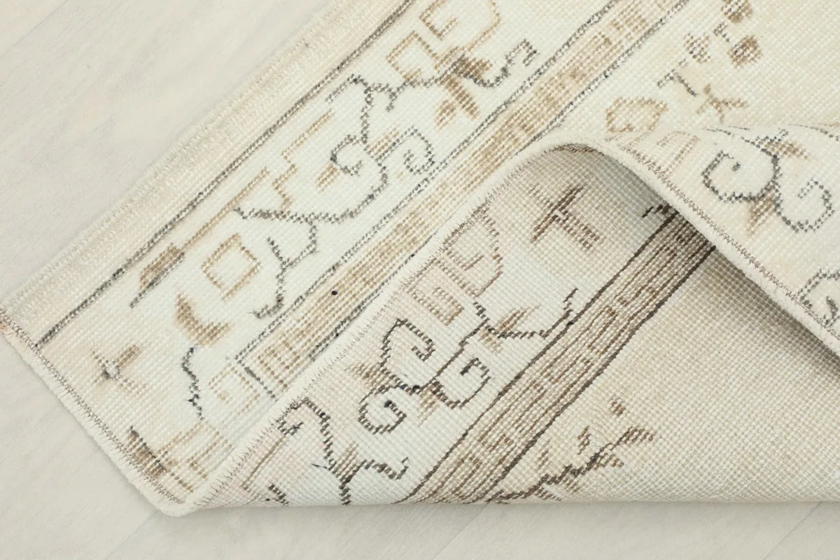 Folded corner of the rug, showing the reverse side and the hand-knotted construction.