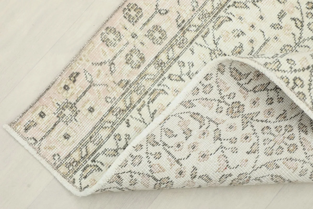 Corner of the rug folded to reveal the cotton foundation and the reverse side of the hand-knotted construction