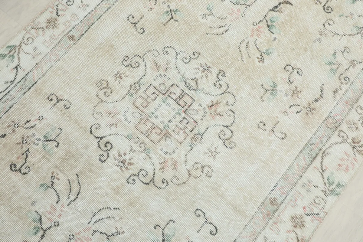 Detailed view of the central medallion and surrounding floral elements on the rug.