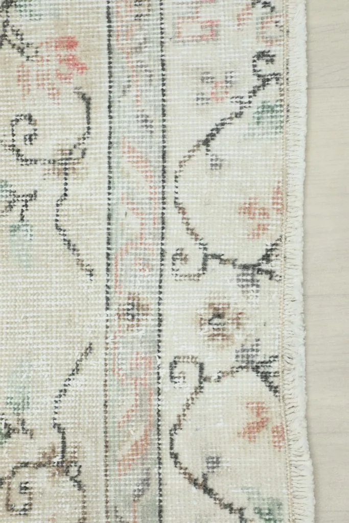 Detail of the rug's border design and edge, showing the hand-knotted construction.