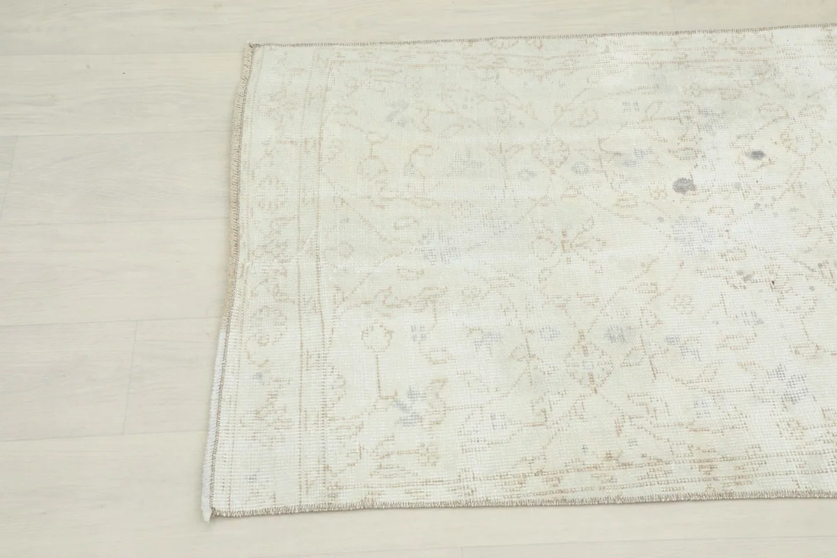 Angled view of the top left corner of the cream beige runner rug