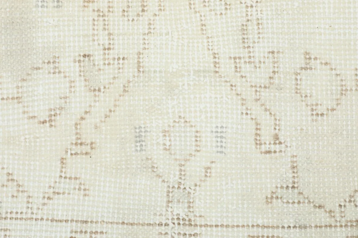 Detailed view of the subtle geometric motifs within the cream beige rug