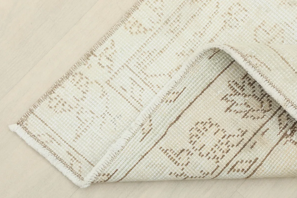 View of the rug's underside and corner, revealing the cotton foundation
