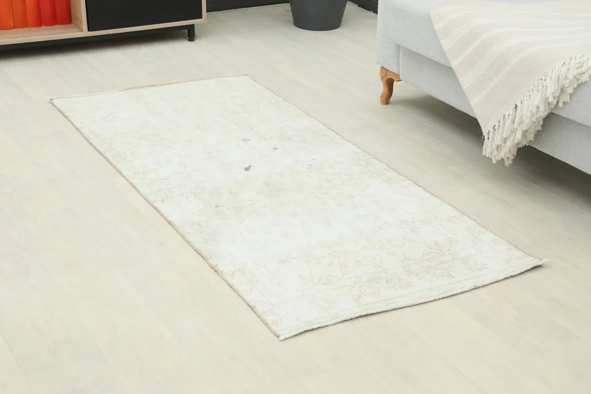 Overhead view of the small cream beige runner rug on a light floor