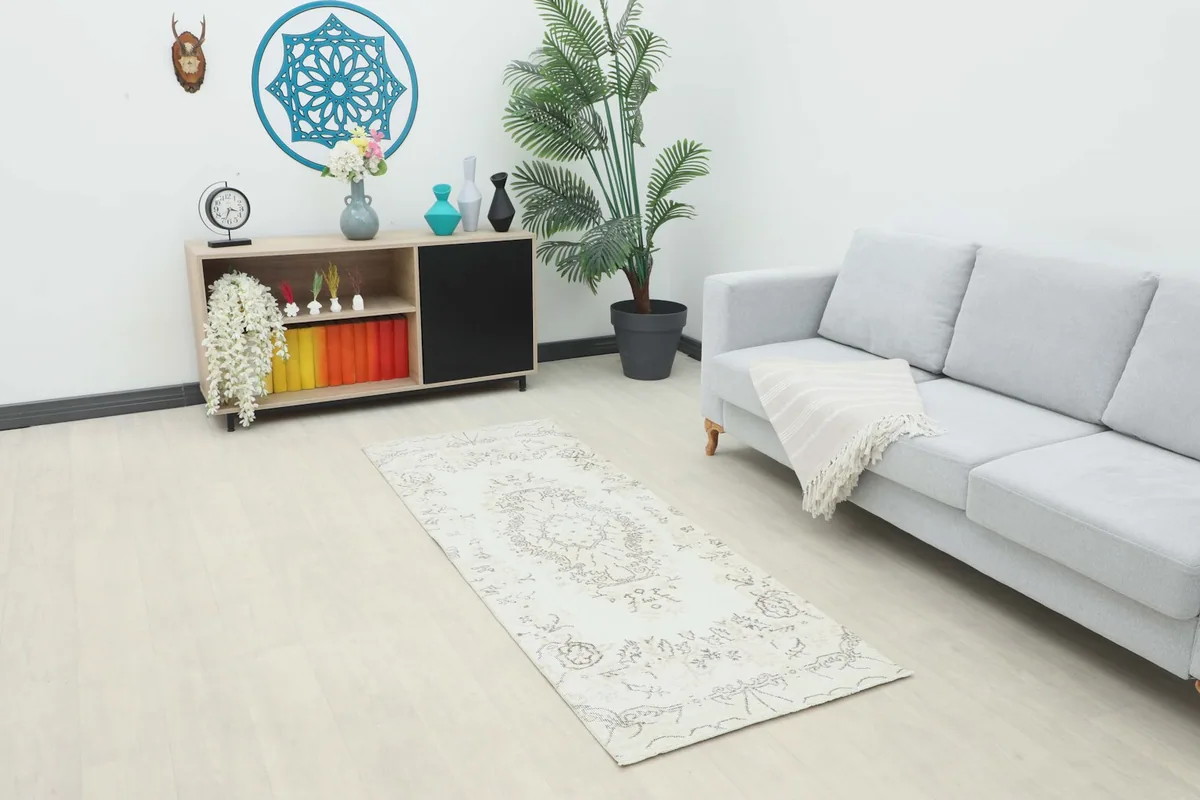 Ivory and gray runner rug placed in a modern living room setting with a light gray sofa