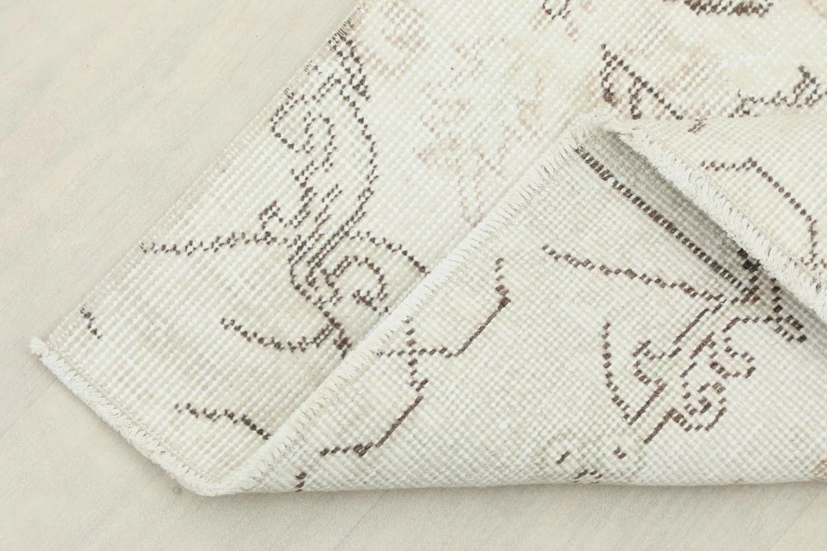 Folded corner showing the cotton foundation and the back of the hand-knotted wool rug