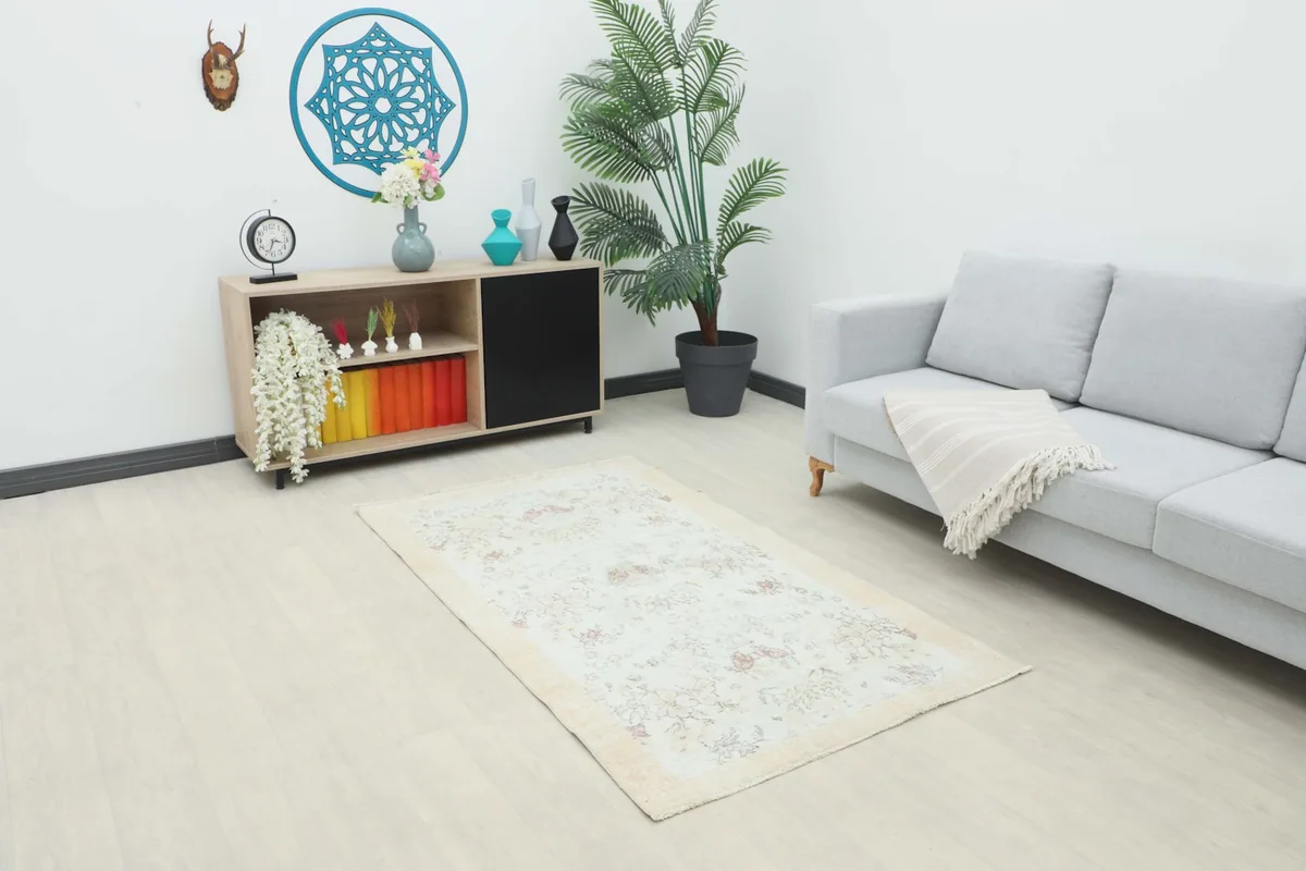 Cream Rose Floral Vintage rug displayed in a modern living room setting with a light gray sofa and wooden cabinet.