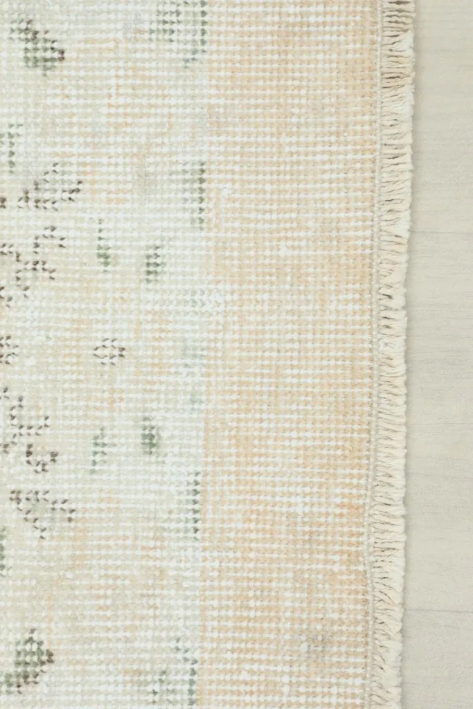 View of the back of the rug, revealing the hand-knotted cotton foundation and wool pile construction.