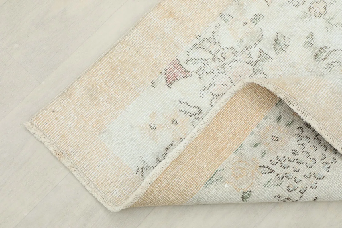 The rug partially folded, showcasing the thickness and flexibility of the hand-knotted wool material.
