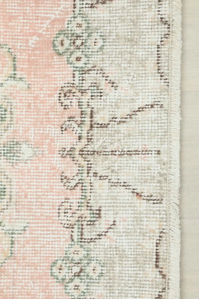 Edge of the rug displaying the border design and hand-knotted fringe