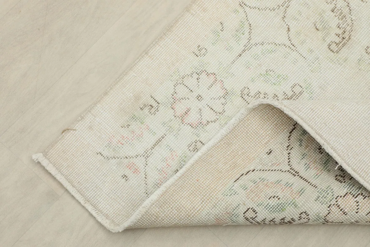 Detail of the rug's reverse side, showcasing the cotton foundation and hand-knotted construction