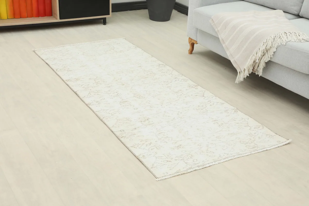 Ivory Floral Anatolian Runner in a room setting, angled view highlighting its length and design.