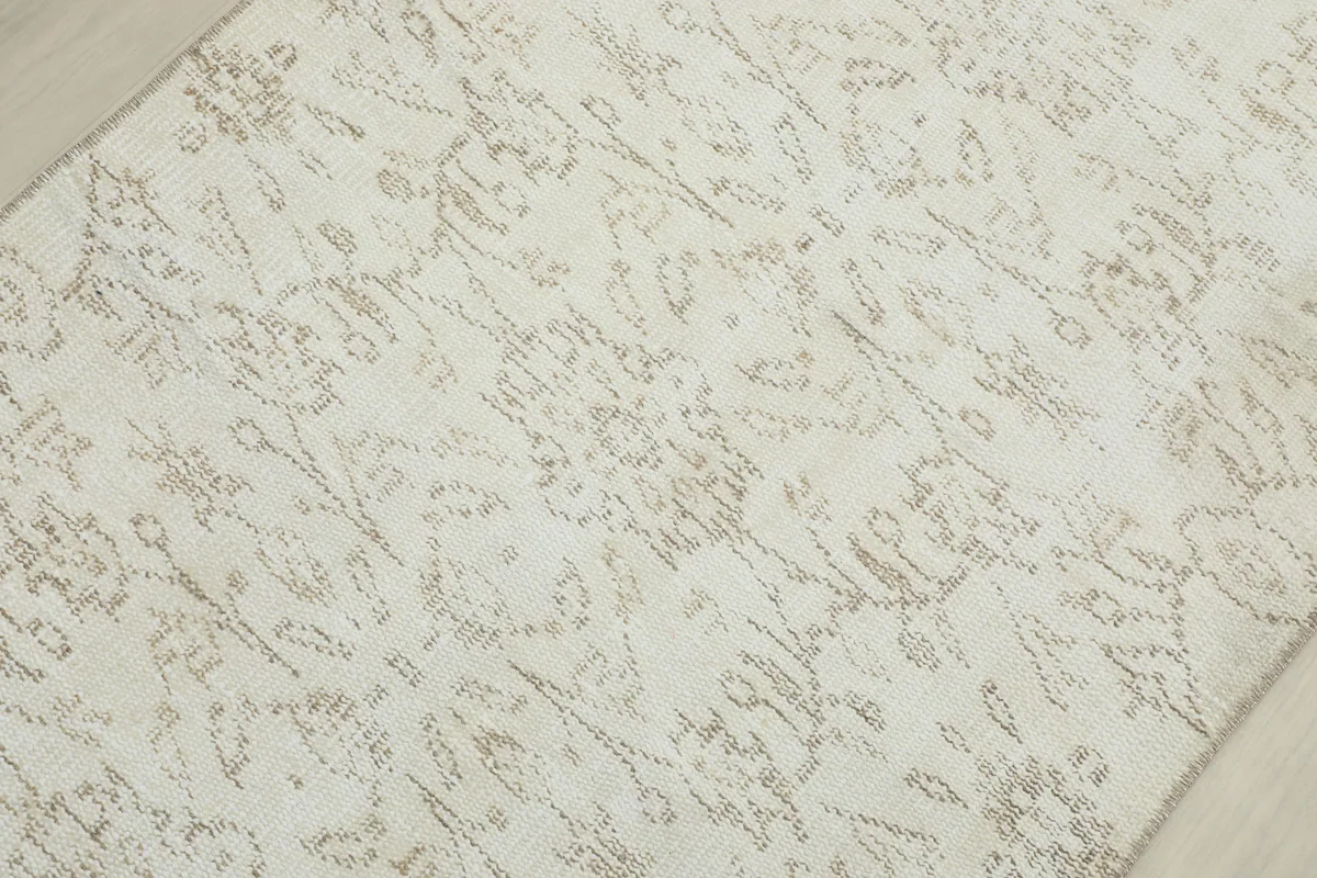 Detailed view of the Ivory Floral Anatolian Runner's surface, highlighting the intricate, faded patterns.