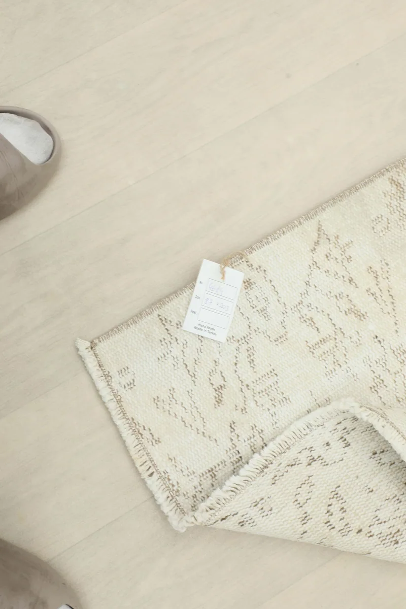 Back of the Ivory Floral Anatolian Runner with the product tag, showing the hand-knotted construction.
