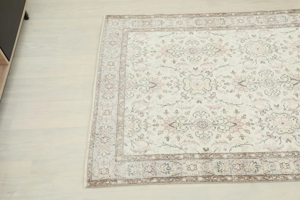 Corner view of the rug showing the intricate floral and geometric motifs and border design.
